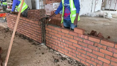 Construction Worker Building Wall with Clay Bricks in Stretcher Bond Pattern Stock Footage 334394174
