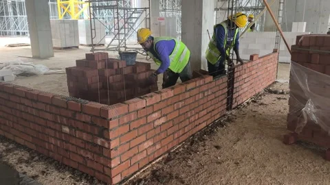 Construction Worker Building Wall with Clay Bricks in Stretcher Bond Pattern Stock Footage 334395033