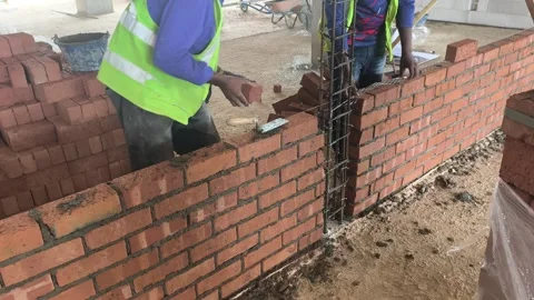 Construction Worker Building Wall with Clay Bricks in Stretcher Bond Pattern Stock Footage 334397258