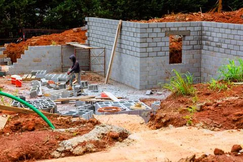 Construction worker builds new structure using blocks at development site in Stock Photos