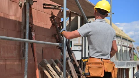 Construction Worker Builds Structure at Job Site During Sunny Day Video stock 314002332