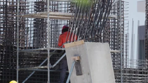 Construction worker builds structure at site in city during the day with metal Stock Footage 338245797