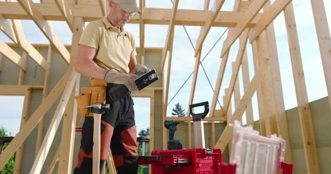 Construction Worker Builds Wooden Framework at a Site During Daylight Hours Video stock 284224751