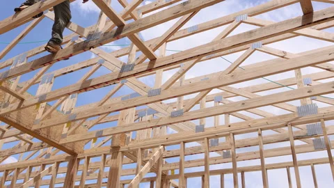 Construction worker builds wooden structure under works day with scattered Video stock 309787196