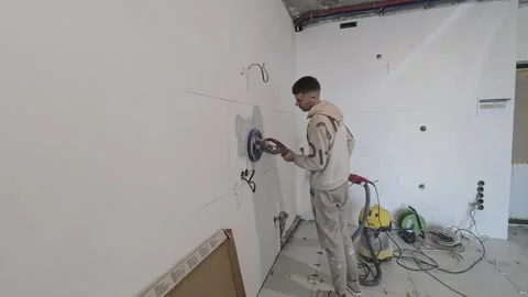 A construction worker is busy installing drywall in the designated area, utilizi Stock Footage 344159417