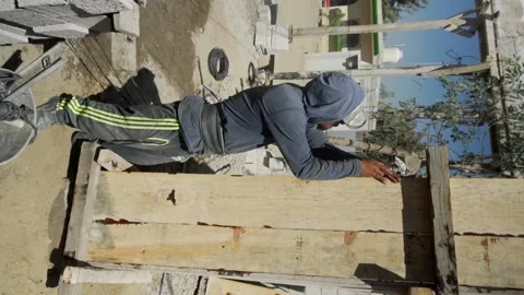 Construction worker in is busy at the unfinished building. Video stock 232083059