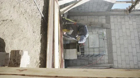 Construction worker in is busy at the unfinished building. 스톡 동영상 232083142