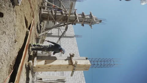 Construction worker in is busy at the unfinished building. Video stock 232083352