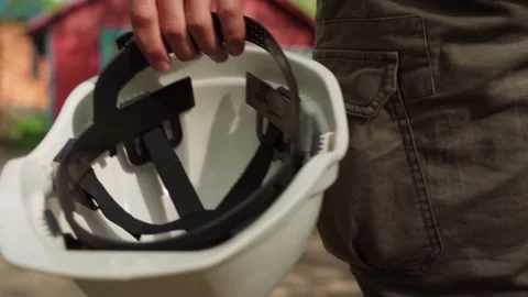 A construction worker carries a white work helmet. close-up Stock Footage 241404982