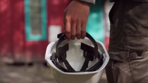 A construction worker carries a white work helmet. Stock Footage 243293281