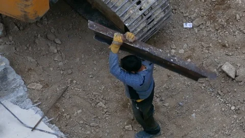 Construction worker carry a piece of girder on his shoulder in construction site Stock Footage 96131402