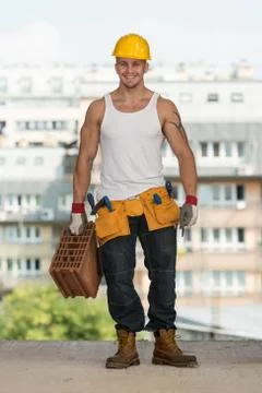 Construction worker carrying brick Stock Photos