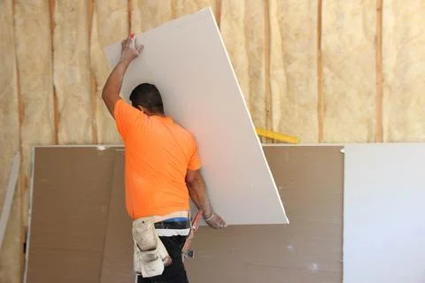 Construction worker carrying drywall Stock Photos