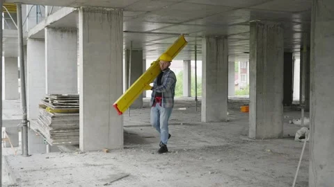Construction worker carrying leveling tool on building site Stock Footage 337467654