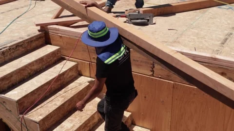 Construction worker carrying lumber up stairs Stock-Footage 228794752
