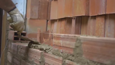 Construction worker cementing brick wall Stock Footage 255684381