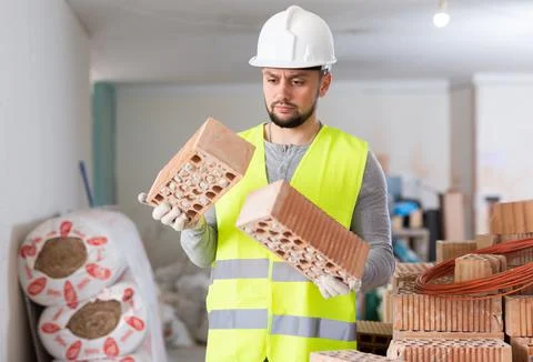 Construction worker checking bricks at renovating object Stock Photos