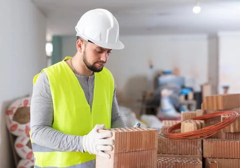 Construction worker checking bricks at renovating object Stock Photos