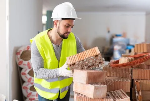 Construction worker checking bricks at renovating object Foto stock