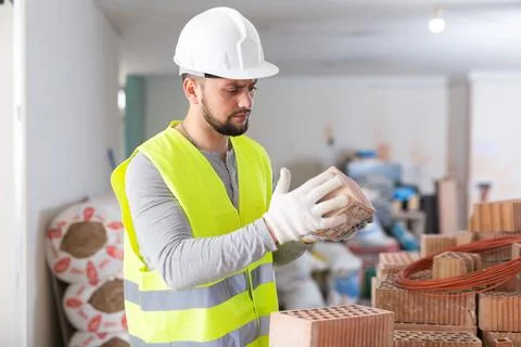 Construction worker checking bricks at renovating object Stock Photos