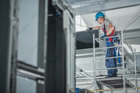 Construction Worker Checking Newly Installed Air Ventilation Shaft On Ceiling Stock Photos