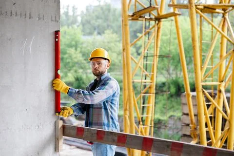 Construction worker checking wall level at building site Stock Photos