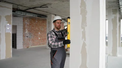 Construction worker checking wall straightness with spirit level Stock Footage 314563489