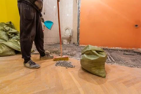 Construction worker is cleaning construction trash in the bags in the toilet Stock Photos