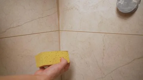 Construction worker is cleaning the excess grout off of the freshly installed Stock Photos