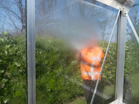 Construction worker cleaning filth with high pressure cleaner from a glass Stock Photos