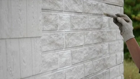 Construction worker cleaning up insulation sheets on house facade wall Stock Footage 194311959