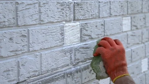 Construction worker cleaning up insulation sheets on house facade wall Stock Footage 194313018
