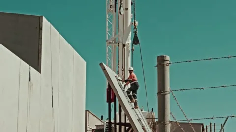 Construction Worker Climbing Concrete Panel to Attach Chains for Crane Lift Stock Footage 305107729