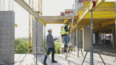Construction worker climbing ladder with architect supervising Stock Footage 343449394