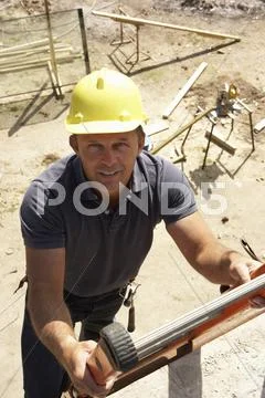 Construction Worker Climbing Ladder On Building Site For New Home Stock Photos
