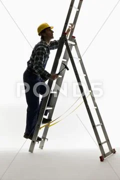 A construction worker climbing a ladder Stock Photos