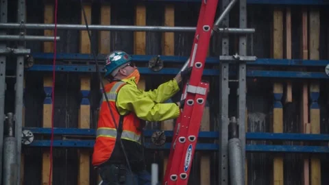 Construction worker climbs ladder Stock Footage 136805014