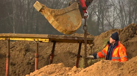 Construction worker close to digger bucket Stock Footage 60449895