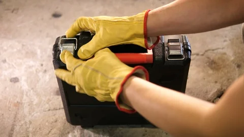 Construction worker closing locking plastic new Tooldbox in the garage. Handyman Stock Footage 126344013