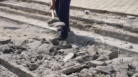 Construction worker collecting construction debris with a shovel Video stock 300760348
