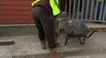 Construction worker collecting debris on a shovel HD Footage