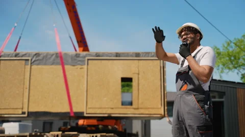 Construction worker communicating with walkie talkie during prefabricated house Stock Footage 316719239