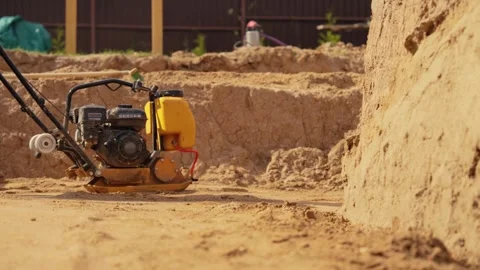 Construction worker compacting sand with vibratory plate Stock Footage 341294871