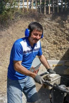 Construction worker compacting soil using compactor. Work with tamping machin Stock Photos
