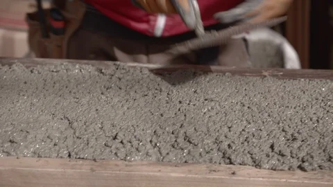 Construction worker compacts concrete and smoothes it with spirit level Stock Footage 99871845