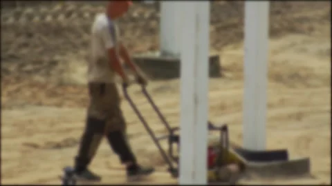 A construction worker compacts soil at a construction site using a special Stock Footage 307207010