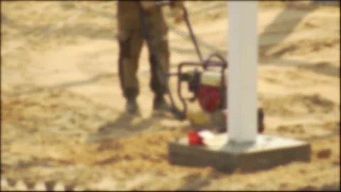 A construction worker compacts soil at a construction site using a special Video stock 309920563