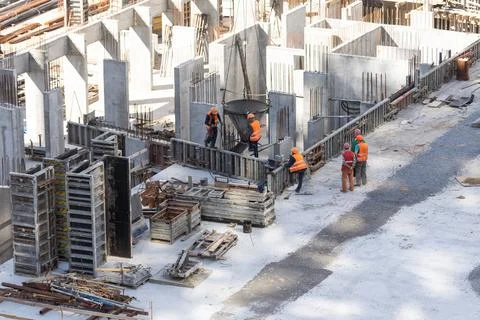 Construction worker Concrete pouring during commercial concreting floors of Stock Photos