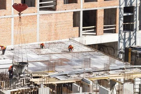 Construction worker Concrete pouring during commercial concreting floors of Stock Photos