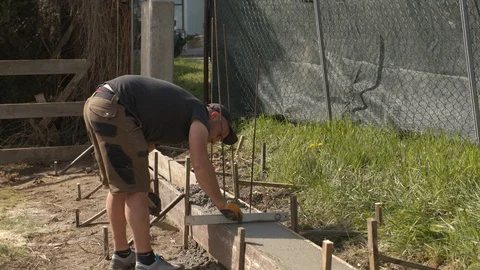 Construction worker concretes a foundation 動画素材 99879046